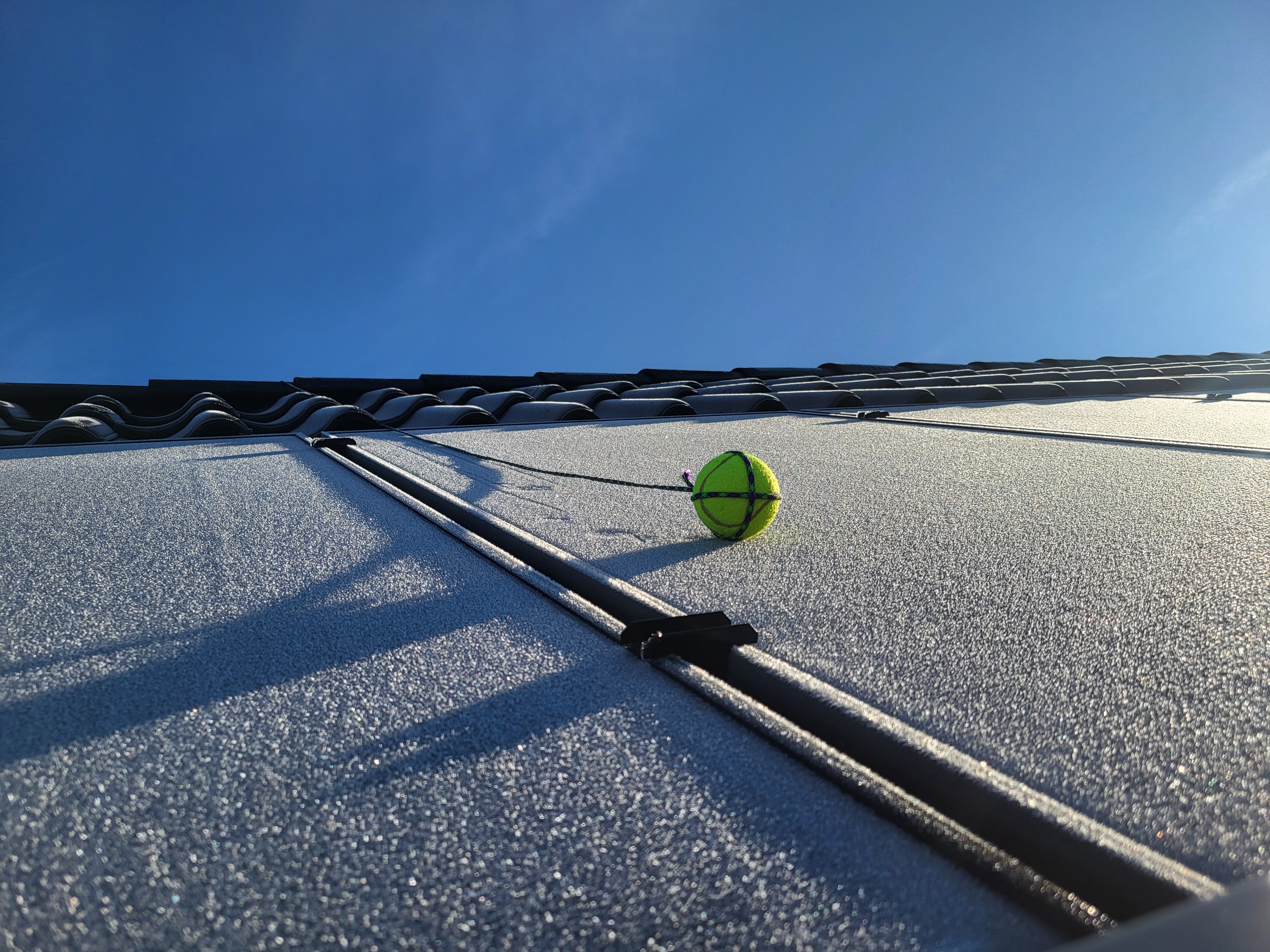 A tennisball on a piece of rope, used to get the rope across